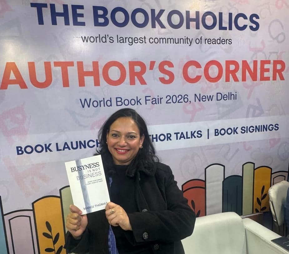 Dr. Vanshree Agarwal holding Manoj Thomas's book at the New Delhi World Book Fair 2026